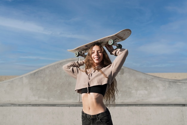 Smiley-Mädchen mit mittlerem Schuss, das Skateboard hält
