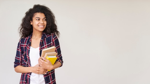 Kostenloses Foto smiley-mädchen mit stapel bücher