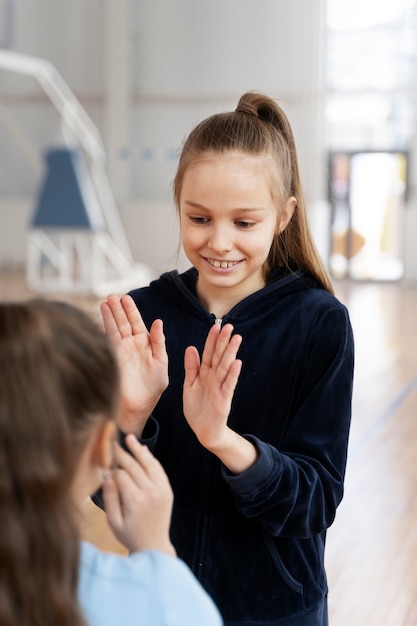 Smiley-Mädchen spielen im Fitnessstudio