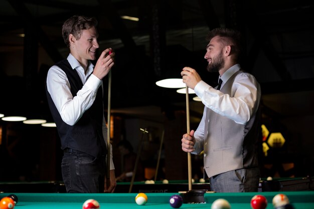 Smiley-Männer mit mittlerer Einstellung und Pool-Cues