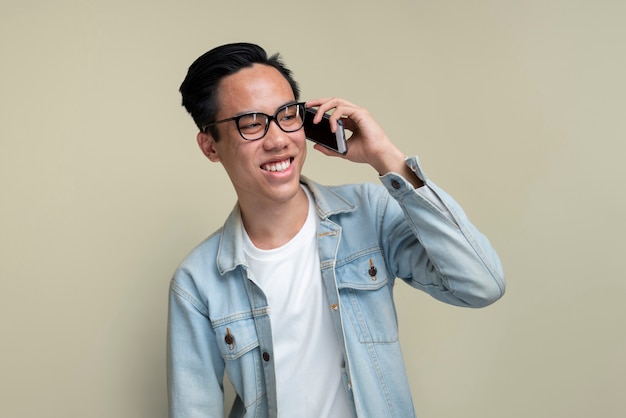 Kostenloses Foto smiley-mann, der am telefon spricht, mittlerer schuss