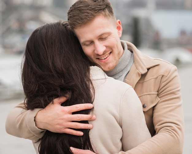 Kostenloses Foto smiley-mann, der frau draußen hält