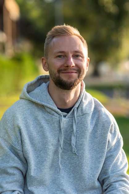 Kostenloses Foto smiley-mann, der sich draußen entspannt