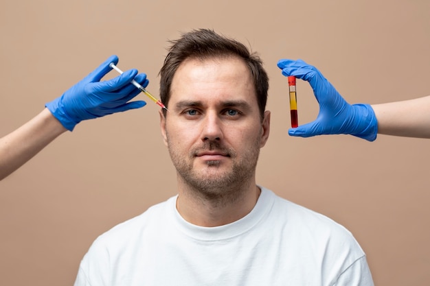 Kostenloses Foto smiley-mann der vorderansicht, der eine prp-injektion erhält