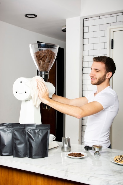 Smiley Mann die Kaffeemaschine abwischen