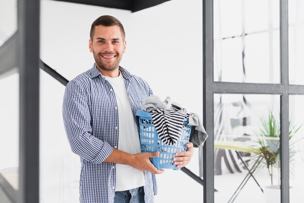 Smiley Mann mit Korb voller Kleidung