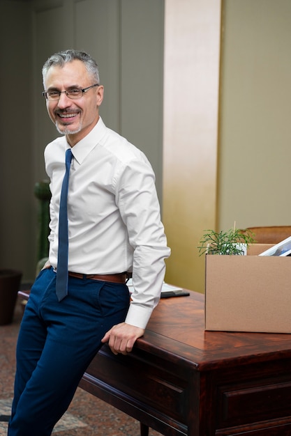 Kostenloses Foto smiley-mann mit mittlerem schuss bei der arbeit