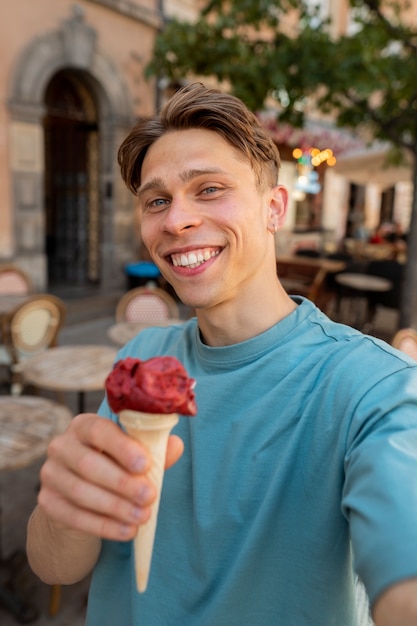 Kostenloses Foto smiley-mann mit mittlerem schuss, der eis hält