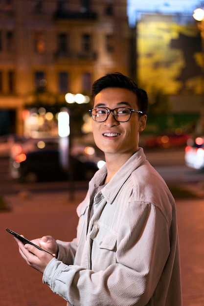 Smiley-Mann mit mittlerem Schuss, der Smartphone hält