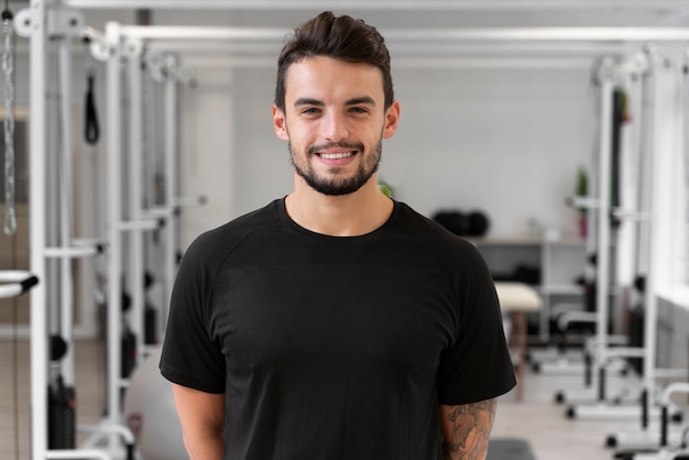 Smiley-Mann mit mittlerem Schuss im Fitnessstudio