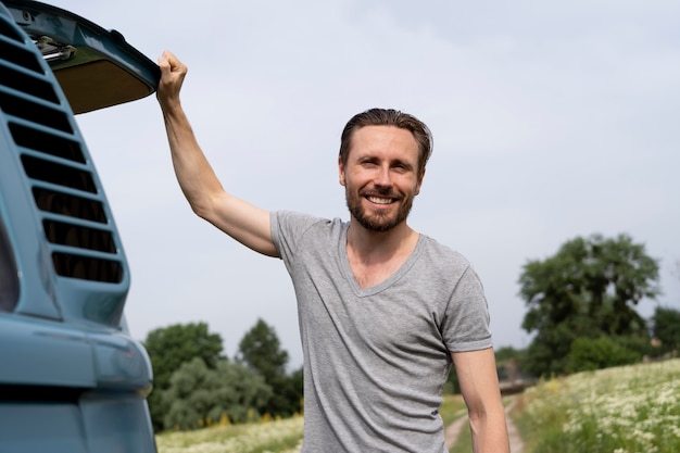 Kostenloses Foto smiley-mann mit mittlerem schuss im freien