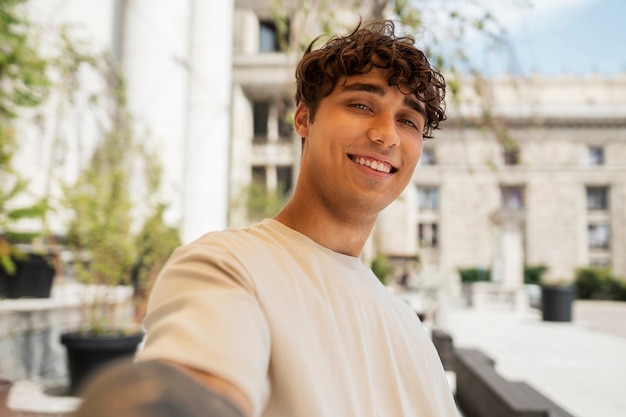 Smiley-Mann mit Seitenansicht, der draußen ein Selfie macht