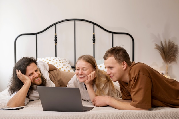 Kostenloses Foto smiley-mitbewohner in mittlerer aufnahme, die im bett liegen