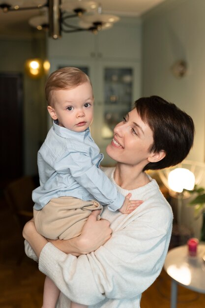 Smiley-Mutter mit mittlerem Schuss, die Baby hält