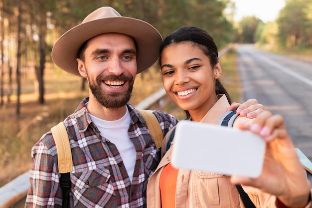 Smiley-Paar, das ein Selfie mit einem Smartphone nimmt