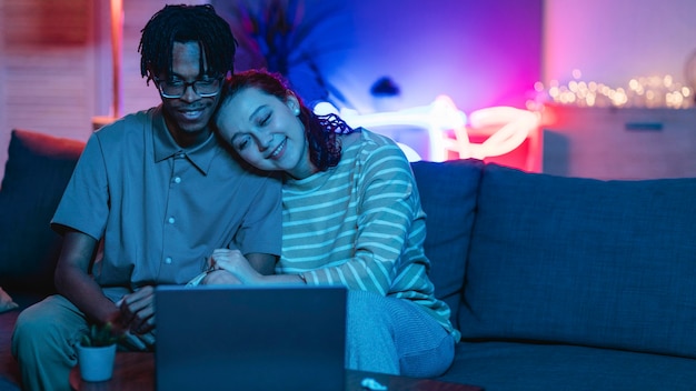 Smiley-Paar, das Laptop zu Hause mit Speicherplatz verwendet