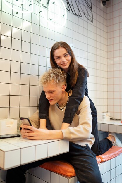 Smiley-Paar mit mittlerem Schuss mit Telefon