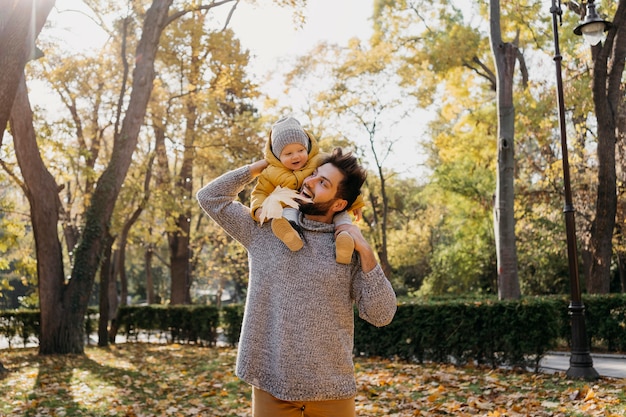 Kostenloses Foto smiley papa mit seinem baby draußen