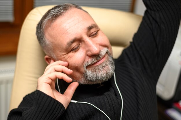 Smiley reifer Mann, der Musik durch Kopfhörer hört