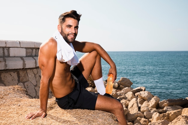 Smiley schöner Mann sitzt nach dem Training