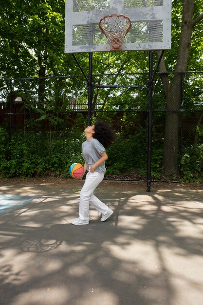 Smiley schwarz Teenager-Mädchen Basketball spielen