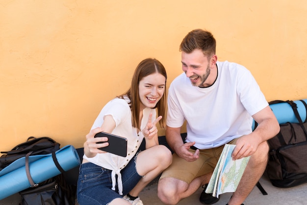 Kostenloses Foto smiley-touristenpaar, das ein selfie mit telefon nimmt