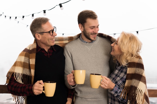 Kostenloses Foto smiley und glückliche familie, die mit schalen aufwerfen