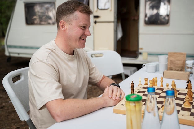 Kostenloses Foto smiley-vater der seitenansicht, der schach spielt