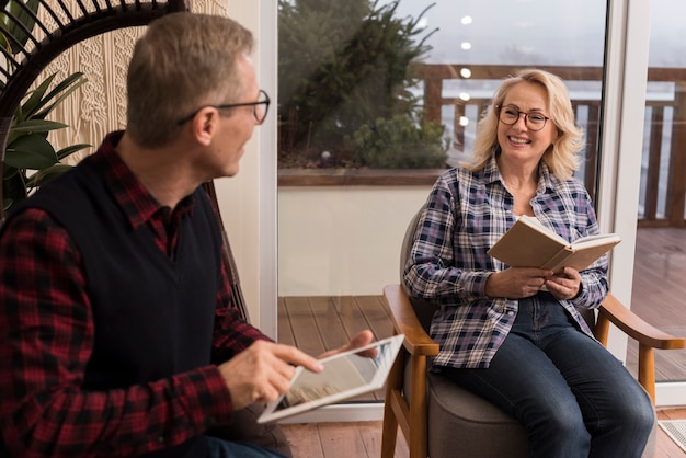 Smileyfamilie zu Hause, die Tablette liest und betrachtet