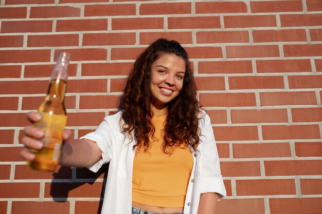 Smileyfrau der Vorderansicht, die Flasche hält