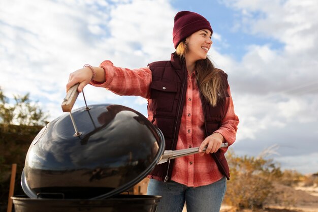 Smileyfrau des mittleren schusses, die grill macht