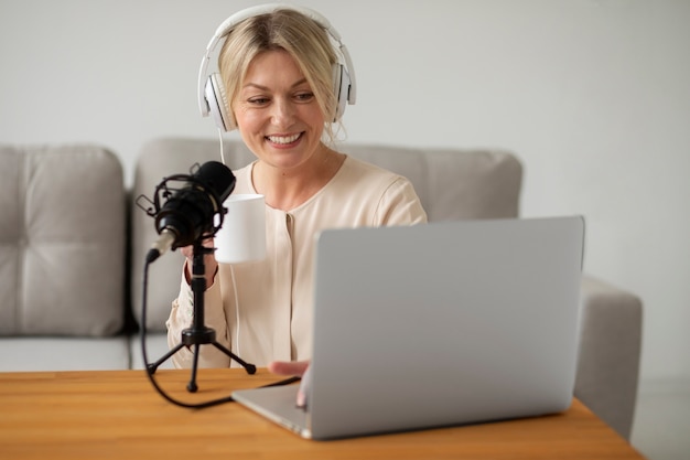 Smileyfrau des mittleren Schusses, die Laptop betrachtet