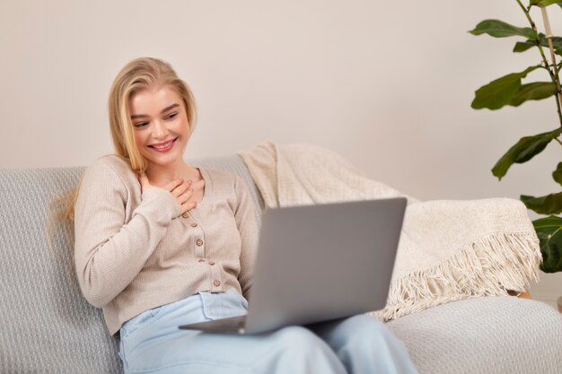 Smileyfrau des mittleren Schusses, die Laptop hält