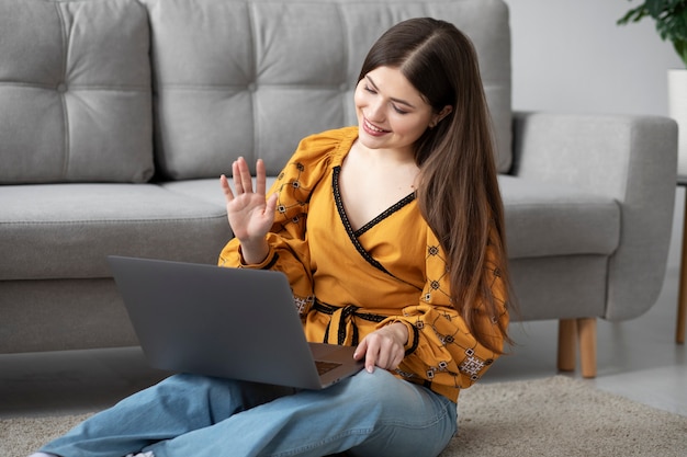 Smileyfrau des mittleren Schusses, die Laptop hält