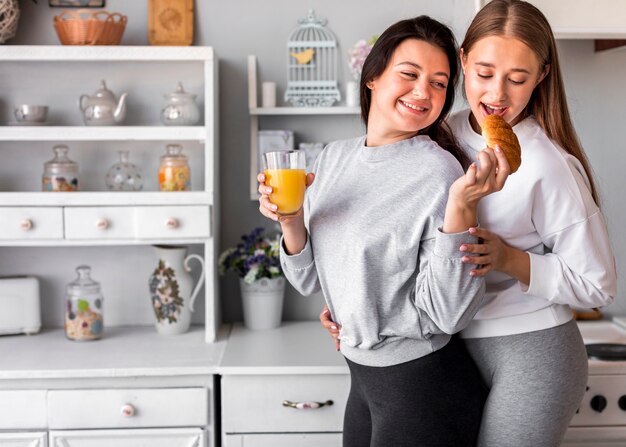 Smileyfrau, die andere beim Halten des Safts ernährt