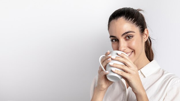 Smileyfrau, die Becher mit Kopienraum hält