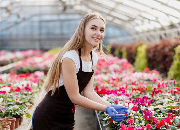 Smileyfrau, die für Blumen sich interessiert