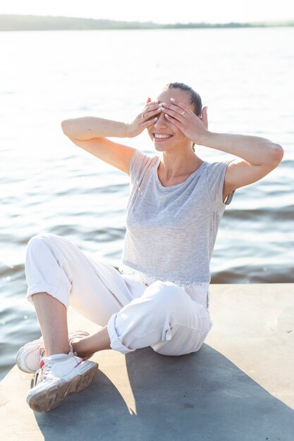 Smileyfrau, die ihre Augen auf Dock bedeckt