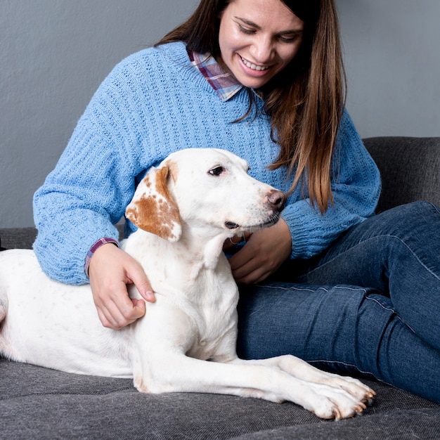 Smileyfrau, die ihren Hund interessiert