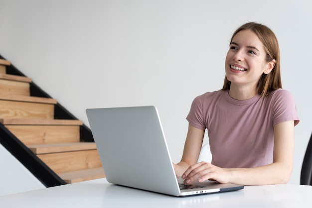 Smileyfrau, die ihren Laptop überprüft