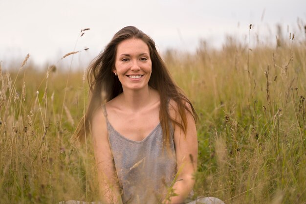 Smileyfrau, die in der Vorderansicht der Natur aufwirft