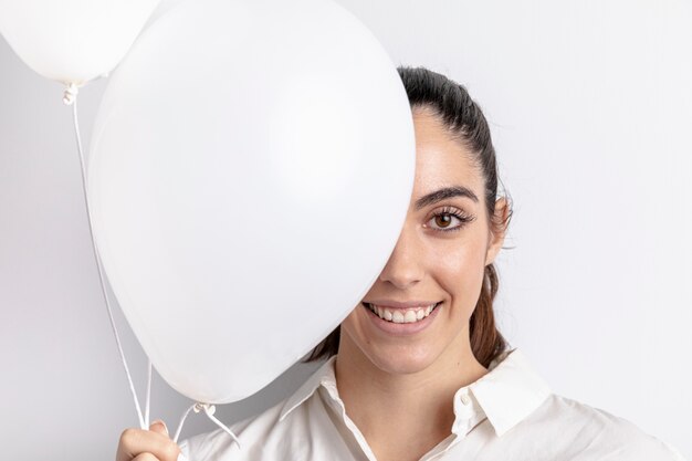 Smileyfrau, die mit Ballonen aufwirft