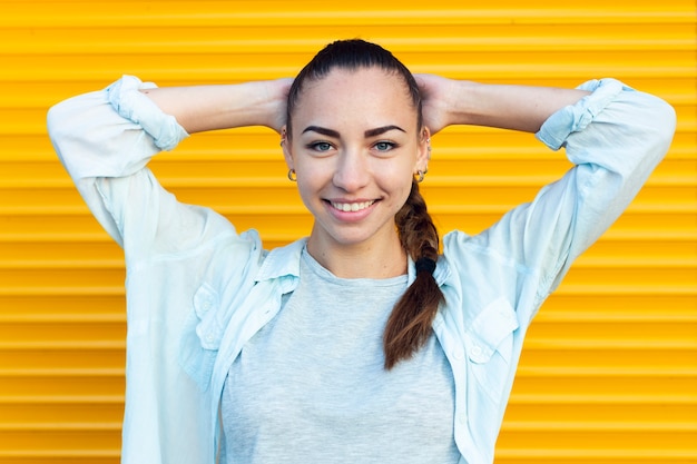 Smileyfrau, die mit gelbem Hintergrund aufwirft