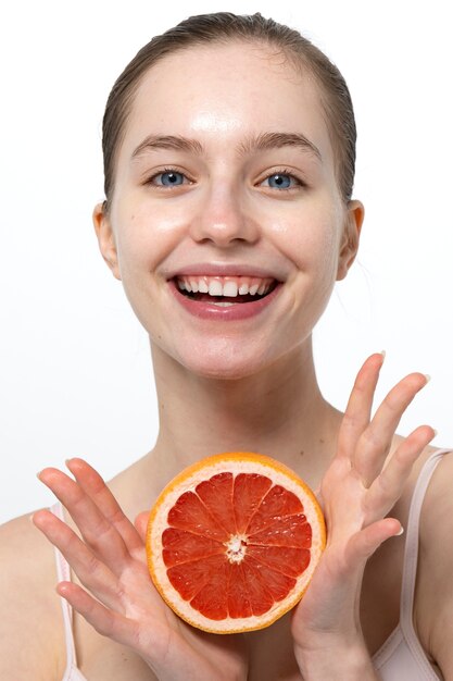 Smileyfrau, die Vorderansicht der Grapefruit hält