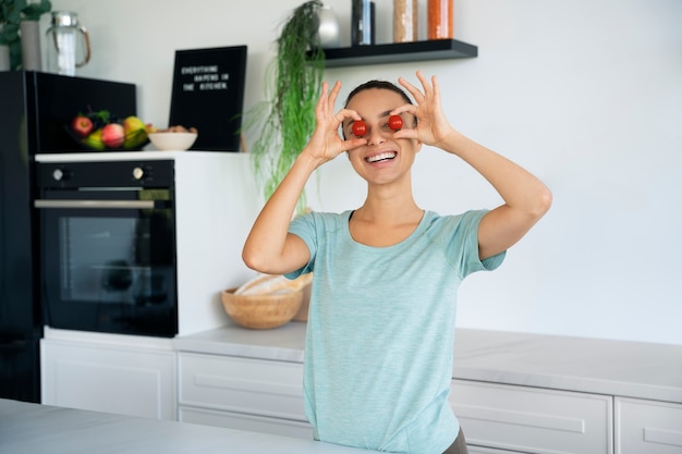 Kostenloses Foto smileyfrau, die vorderansicht der kirschtomaten hält