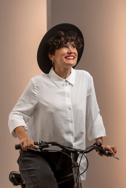 Smileyfrau mit mittlerer Aufnahme auf dem Fahrrad