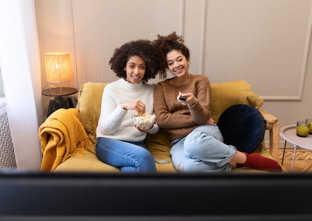 Smileyfrauen des mittleren Schusses, die fernsehen