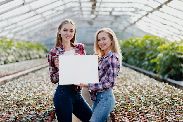 Smileyfrauen, die unbelegtes Blatt anhalten