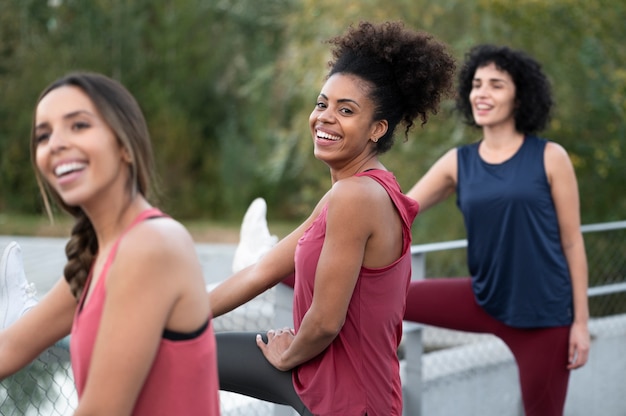 Smileyfrauen mit mittlerem Schuss, die sich dehnen