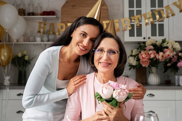 Smileyfrauen mit mittlerer Aufnahme, die mit Blumen posieren